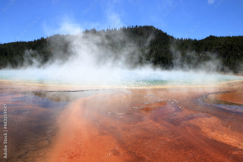 The red soil around the Grand Prismatic spring is from bacteria that thrive in hot acidic environments