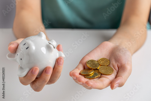 Obraz na plátne Hand picking piggy bank and money coin, crisis, financial problems, not enough, financial savings, need for money, business, investment, retirement