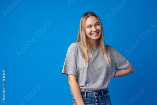 Cuadro en lienzo Happy smiling pretty teenage girl laughing over blue background