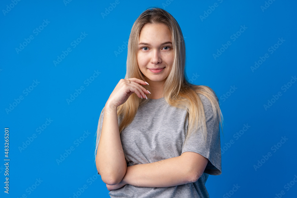 Pretty smiling girl portrait against blue background in studio Pretty smiling girl portrait against blue background in studio