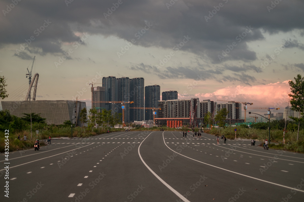 People jogging on the wide avenue in a big city. Skyscrapers on the background. Sunset in the metropolis. Beautiful sky. High quality photo