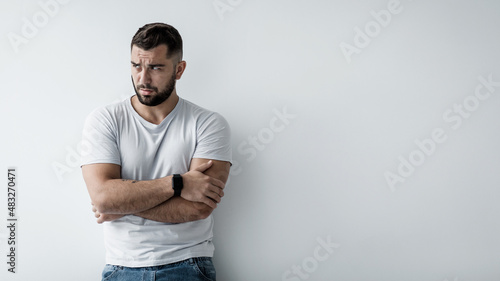 Guilty sad unhappy pensive millennial caucasian handsome guy with crossed arms