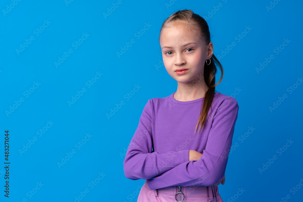 Portrait of a little smiling girl preteen on blue background Portrait of a little smiling girl preteen on blue background