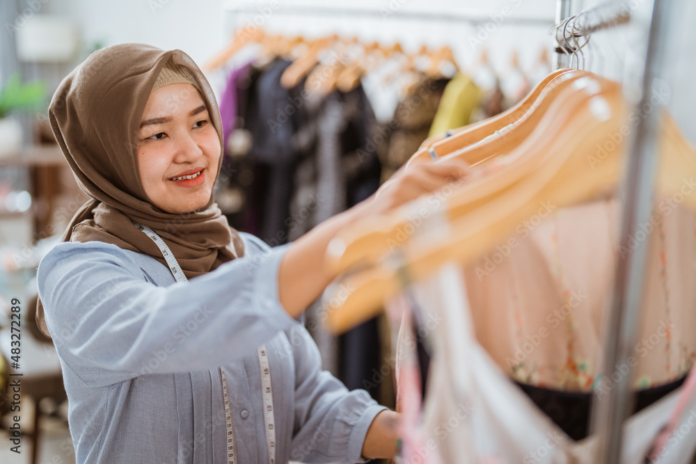 muslim fashion designer checking her dress product