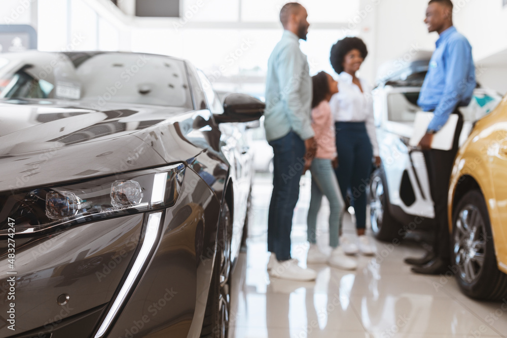 Fototapeta premium Young black family with child buying new car, consulting salesman at auto dealership, selective focus