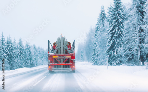 Truck on the road in winter in northern Finland. Snow covered trees.