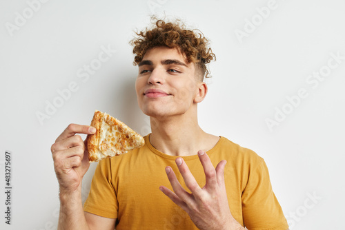 kinky guy in a yellow t-shirt eating pizza Lifestyle unaltered