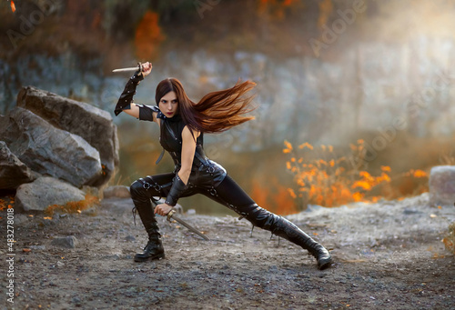 Obraz na plátne Fantasy fighting woman assassin actions in motion battle, hold daggers in hand
