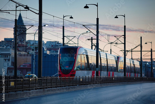 A modern tram rides across the Galata Bridge in Istanbul early in the morning.