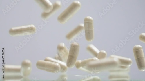 Pills capsules falling from top to bottom in slow motion photo
