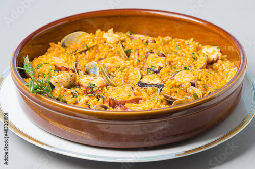 Octopus clay bowl with rice and clams, typical dish from Galicia (Spain)