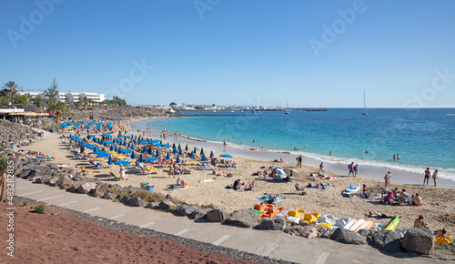 Fototapeta Naklejka Na Ścianę i Meble -  Playa Blanca, Lanzarote (Spain) on Januari 23, 2022: Tourist enjoying the beach and sun during the winter period