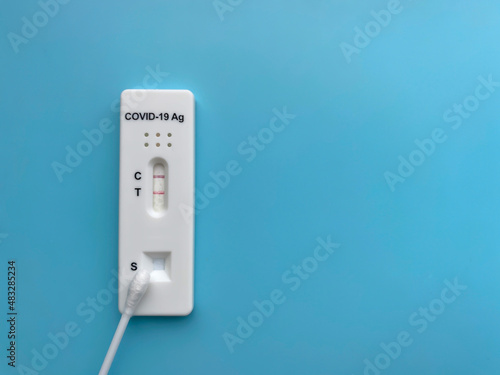 Positive rapid test result for Covid-19. Close-up of a device for the rapid detection of coronavirus (sars-CoV-2) antigen.  Isolate On a blue background, top view, flat lay, copy space.
