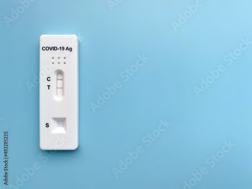 Positive rapid test result for Covid-19. Close-up of a device for the rapid detection of coronavirus (sars-CoV-2) antigen.  Isolate On a blue background, top view, flat lay, copy space.