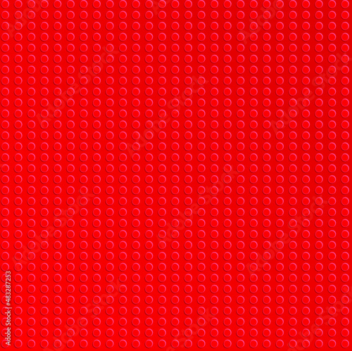 Red plastic constructor blocks plate. Abstract background