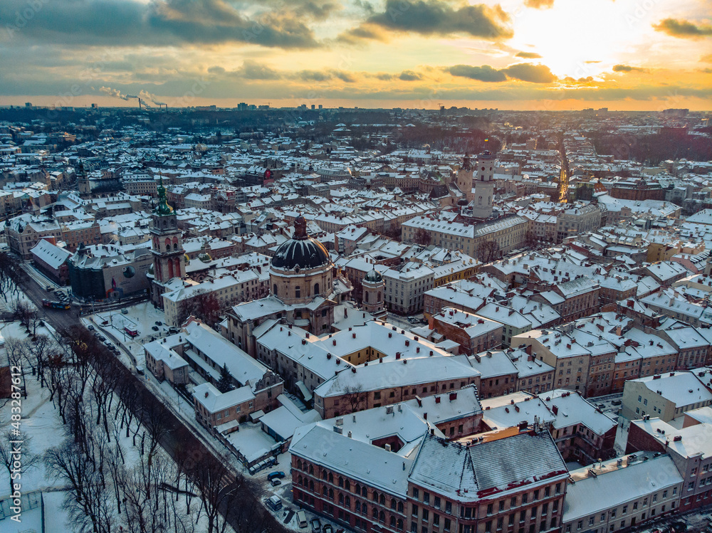 Aerial shot of Old City Lviv cowered by snow with churches and cathedrals.