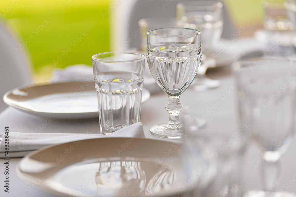 serving of the festive table. an empty white plate and glasses on the table. serving of the festive table. an empty white plate and glasses on the table.