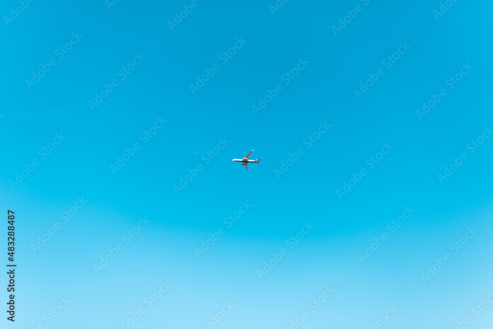 Fototapeta premium Beautiful clear blue sky with a plane high in the sky. Travel concept
