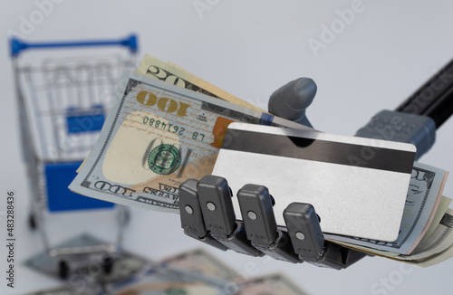 robot hand holds money and a credit card. concept of trading using artificial intelligence.