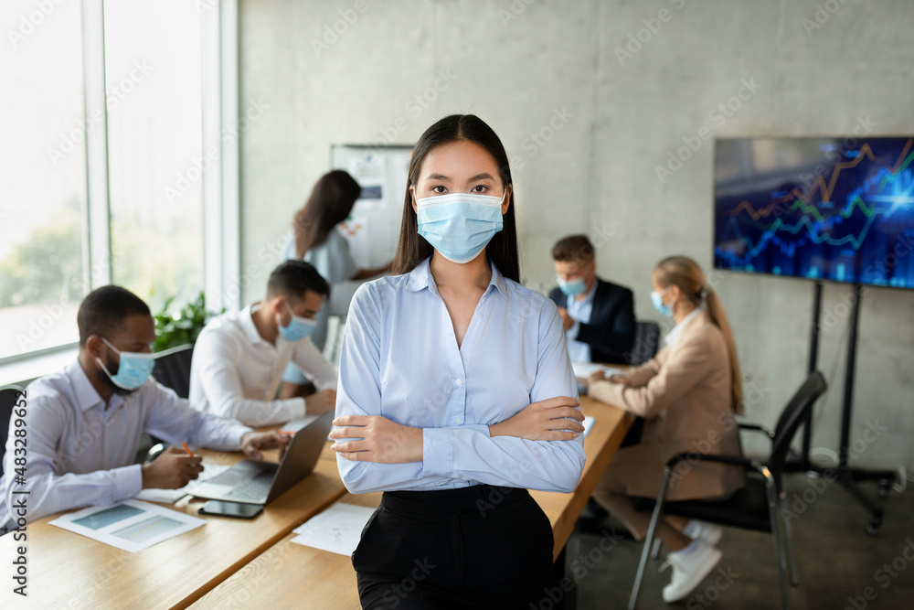 Covid-19 And Entrepreneurship. Portrait of confident young asian businesswoman in medical mask