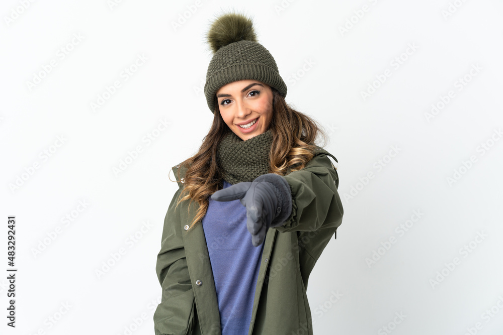 Young girl with winter hat isolated on white background shaking hands for closing a good deal Young girl with winter hat isolated on white background shaking hands for closing a good deal