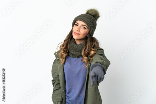 Young girl with winter hat isolated on white background pointing front with happy expression