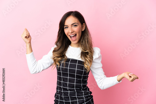 Young caucasian woman isolated on pink background celebrating a victory