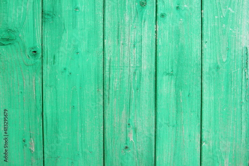 Old green wooden wall with cracked paint, background texture.