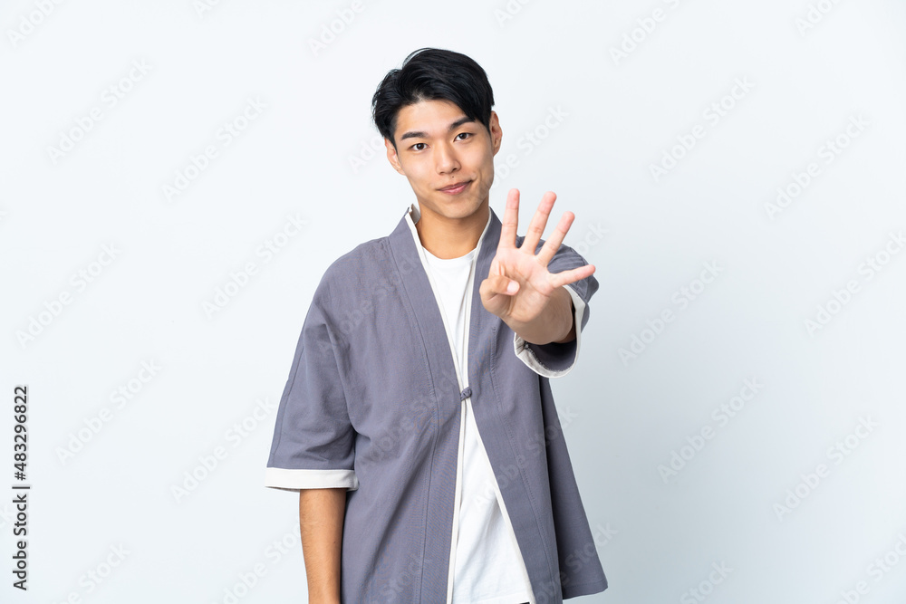 Young Chinese man isolated on white background happy and counting four with fingers Young Chinese man isolated on white background happy and counting four with fingers