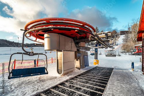 Empty chairs at vottom station of ski-lift chair at resort Snowland Valca in winter season. photo