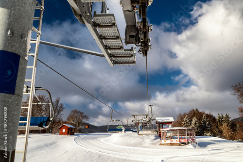 Empty chairs at station of ski-lift chair at resort Snowland Valca in winter season. photo