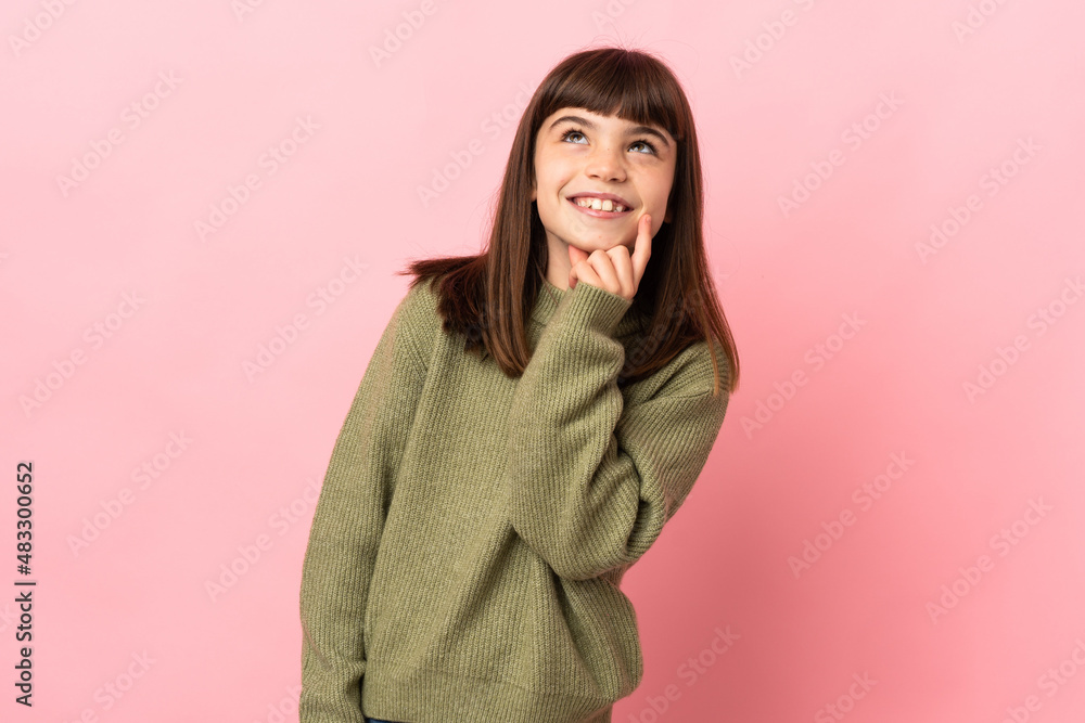 Little girl isolated on pink background thinking an idea while looking up Little girl isolated on pink background thinking an idea while looking up