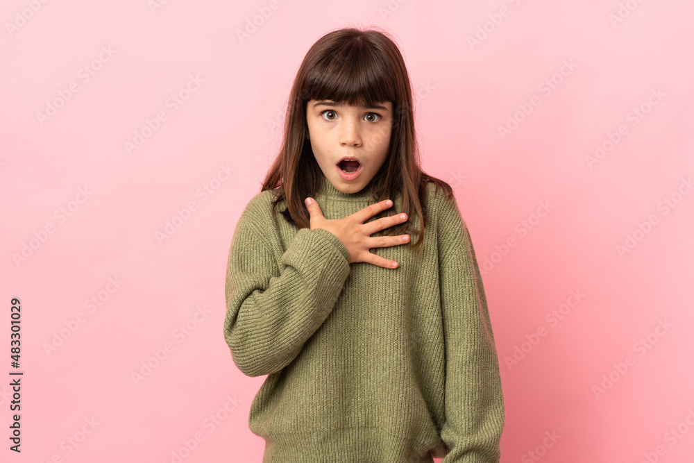 Little girl isolated on pink background surprised and shocked while looking right Little girl isolated on pink background surprised and shocked while looking right