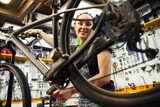 Cheerful female technician repairing bike
