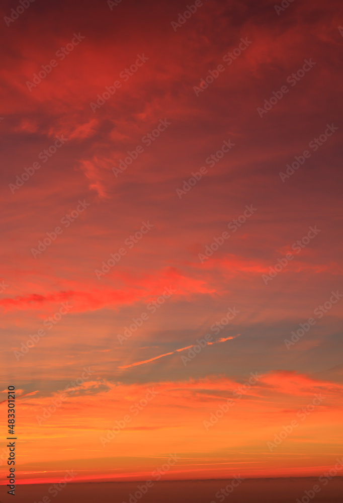 Red sunrise with clouds with sea in the background. Vertical photo