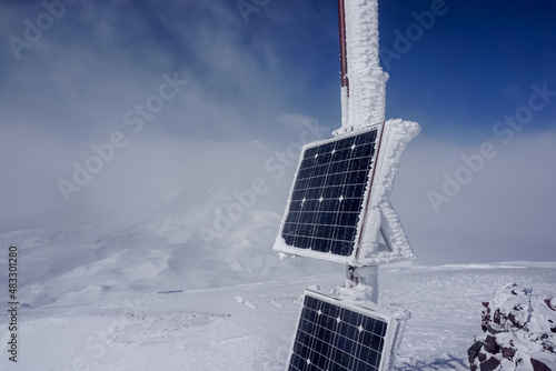 Frozen solar panel on the ridge of Avachinsky volcano in winter photo