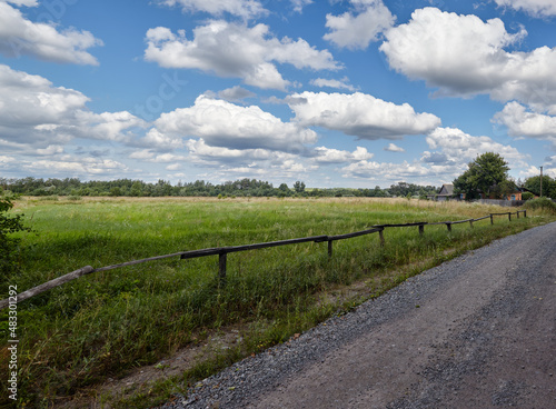 Panoramic photo of a gravel road at rural Europe. Suburban road path © supersomik