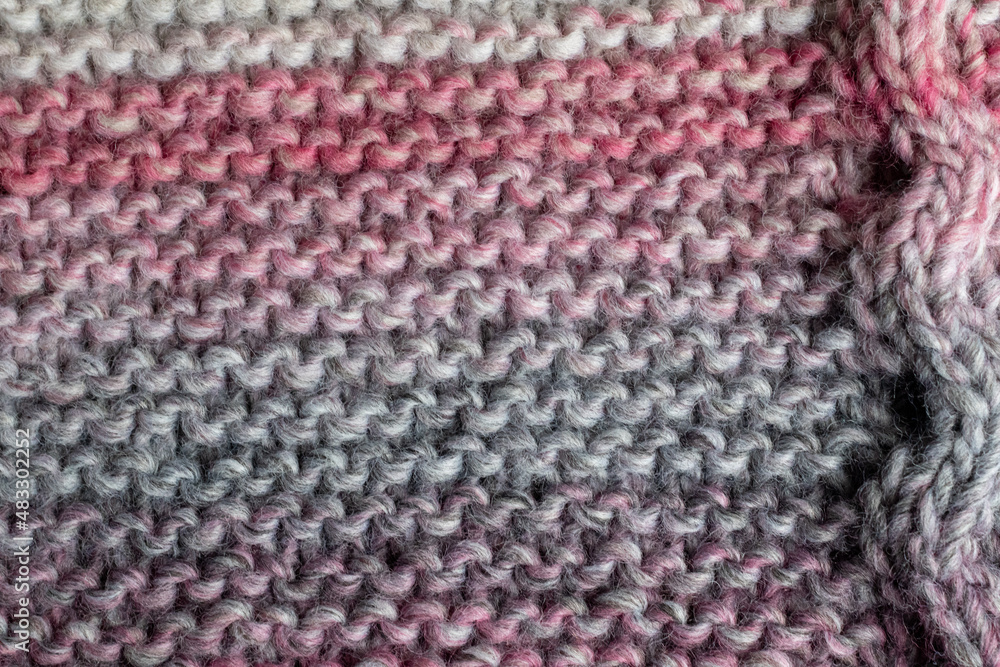 knitting backdrop of hand knit wool fabric in colours of grey and pink knitting backdrop of hand knit wool fabric in colours of grey and pink