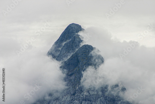 misty mountaintops showing thorugh clouds photo
