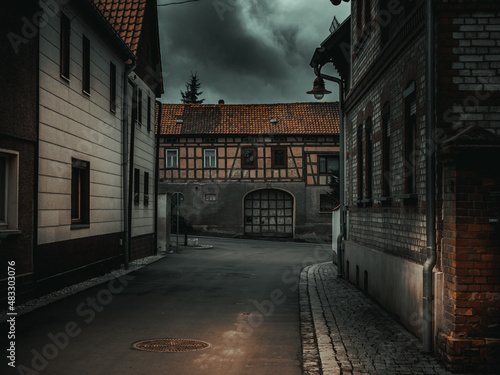 atmospheric Dark street of an old German city with thunderclouds © luchschenF