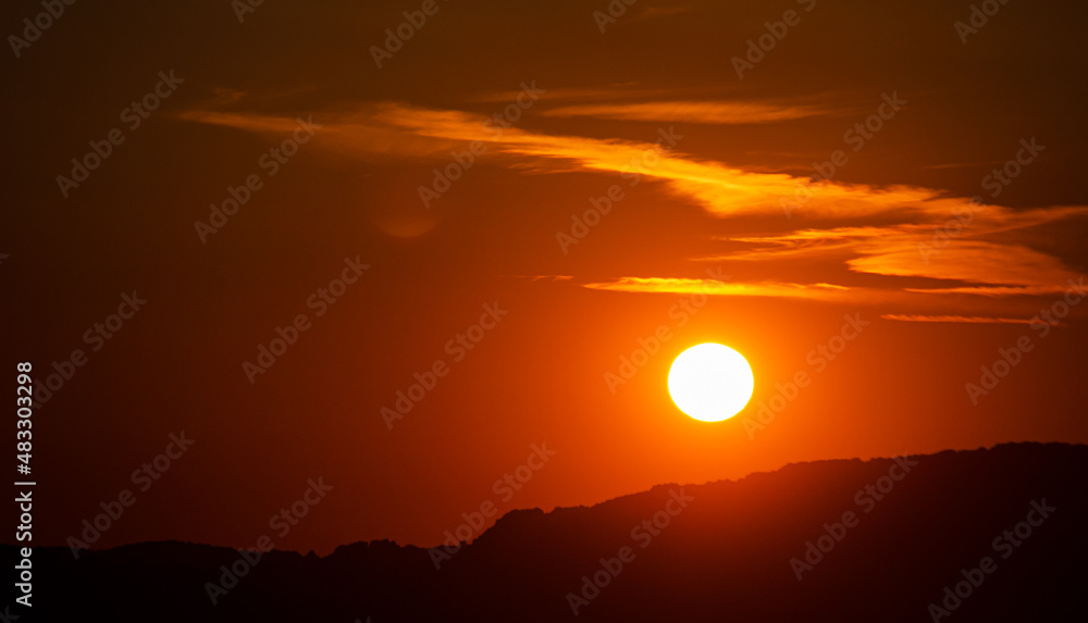 Beautiful summer sunset with orange sky and some hills landscape in Transylvania, Romania.