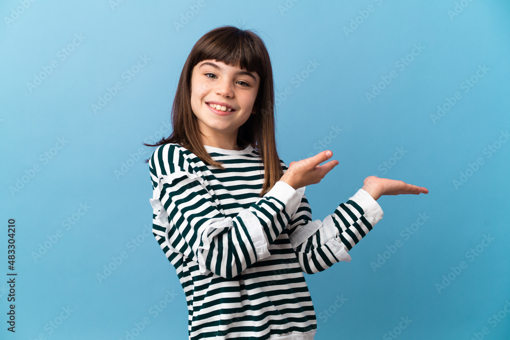 Little girl over isolated background holding copyspace imaginary on the palm to insert an ad Little girl over isolated background holding copyspace imaginary on the palm to insert an ad