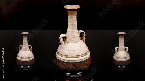 video of a ceramic jug rotating with 2 smaller symmetrical jugs on each side rotating on a black background