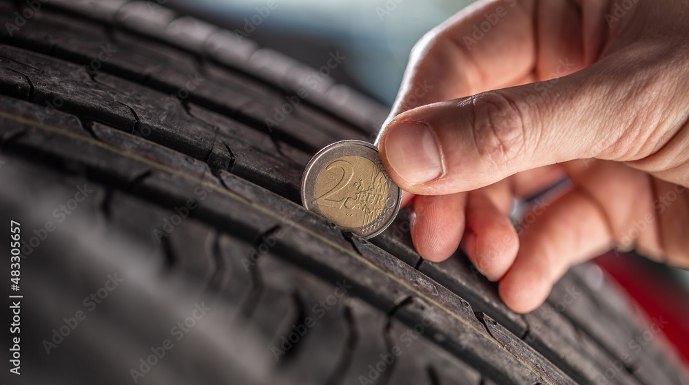 Tire tread measuring by a two euro coin placed into the pattern of the