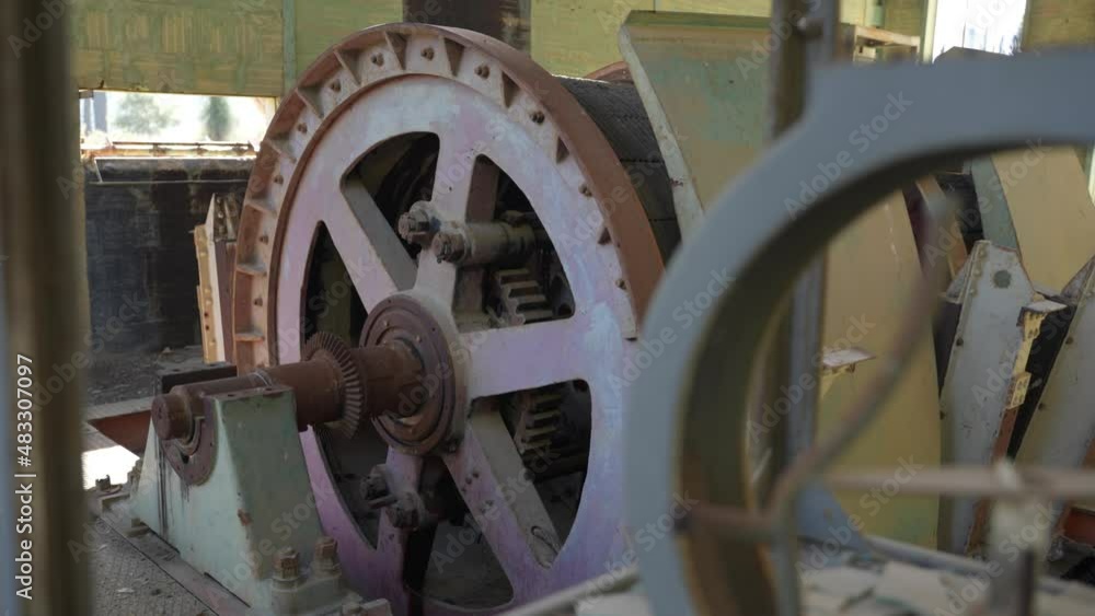 View of the large cogs and gears inside an abandoned mine site.