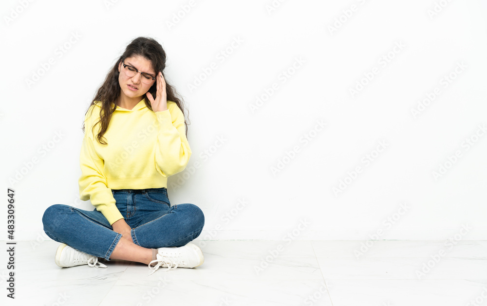 Teenager Russian girl sitting on the floor with headache Teenager Russian girl sitting on the floor with headache