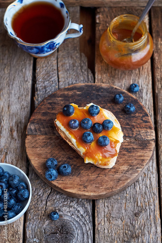 Fototapeta Naklejka Na Ścianę i Meble -  Toast with butter, caramel and blueberries. Top view, wooden background.
