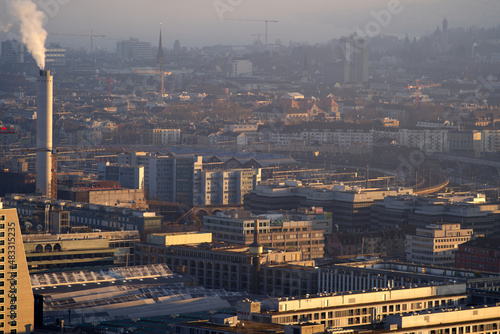Aerial view over City of Z  rich with the Swiss Alps and hazy sky in the background on a sunny winter afternoon. Photo taken January 26th  2022  Zurich  Switzerland.