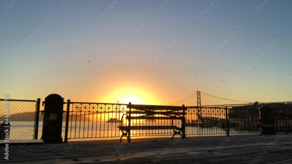 Sunrise over the Bay Bridge with bench and boat Sunrise over the Bay Bridge with bench and boat