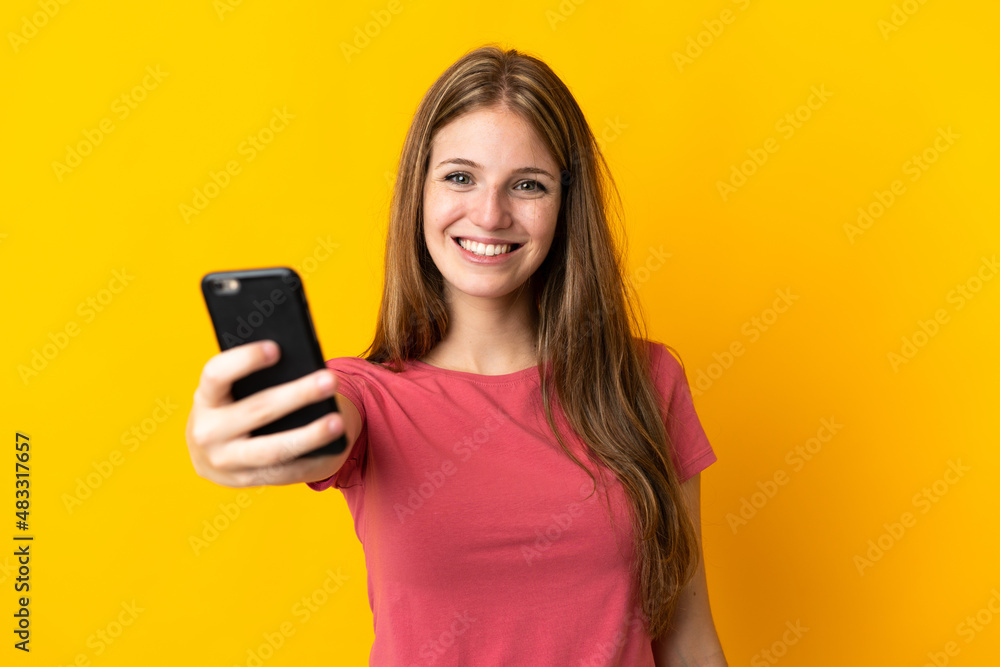 Young woman using mobile phone isolated on yellow background with happy expression Young woman using mobile phone isolated on yellow background with happy expression